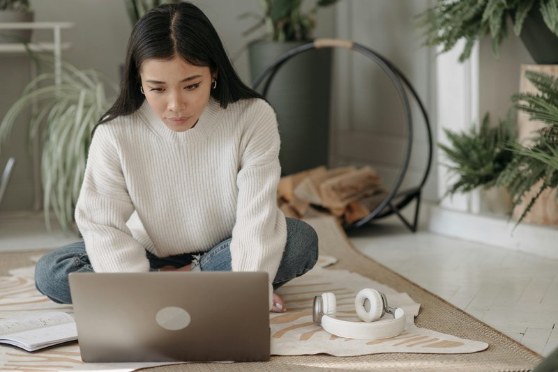 Woman managing finances with computer, phone and papers